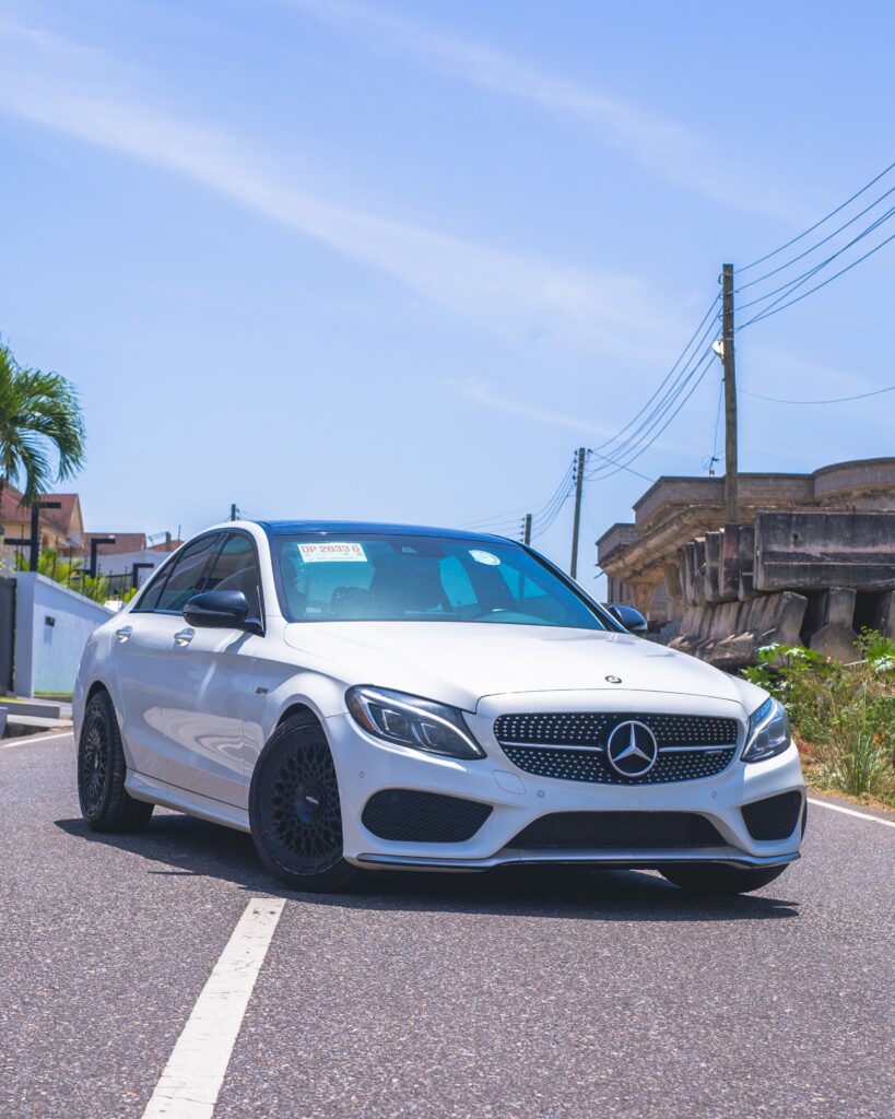pexels photo 36806215 36806215 Stylish white Mercedes parked on the road under a clear blue sky.
